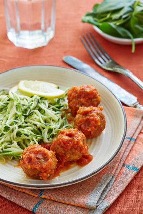 Gatavās gaļas bumbiņas tomātu mērcē pasniegtas ar cukīni spageti