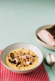 Skābu kāpostu un kāļu krēmzupa ar kūpinātiem cūkas vaigiem un grauzdētiem lazdu riekstiem