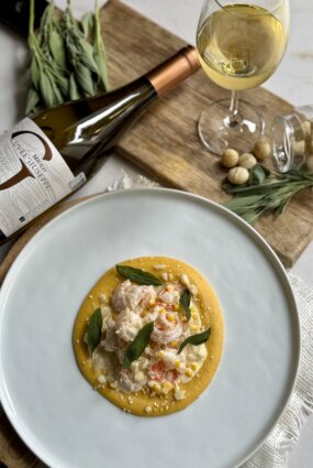 Tīģergarneles ar sviestā ceptas kukurūzas – saldā krējuma mērci, Makadāmijas riekstiem, ķirbju – ingvera biezeni un fritētu salviju.