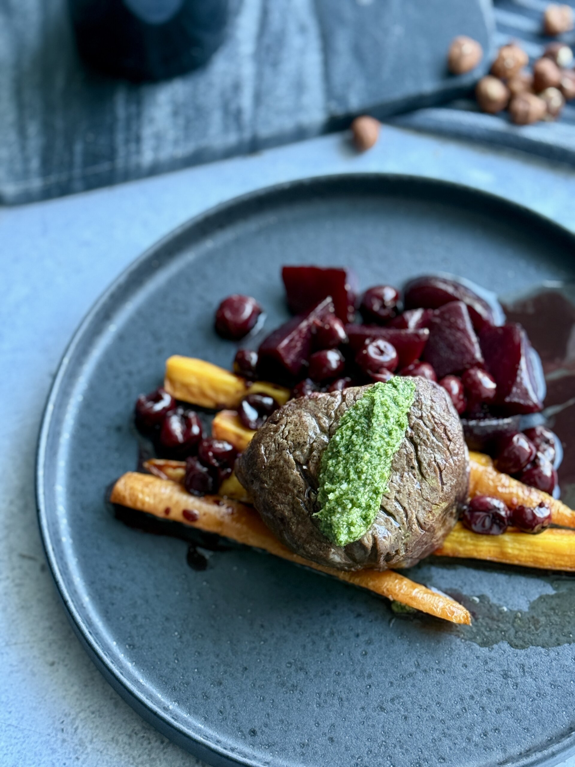 Liellopu medaljons, rozmarīnā ceptas saknes (burkāni un bietes), balzametiķa un ķiršu redukcijas mērce un lakstu pesto