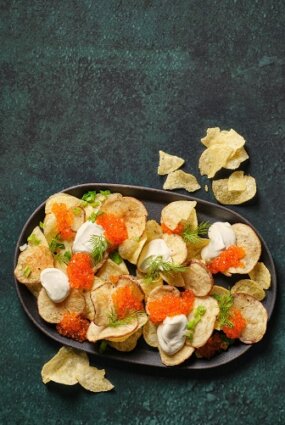 Čipsu uzkoda ar tecinātu krējumu un foreles ikriem