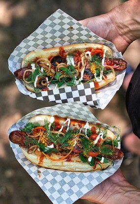 HOTDOGS AR BEKONU, CEPTIEM ĶIRŠU TOMĀTIEM UN FRITĒTIEM ŠALOTES SĪPOLIEM