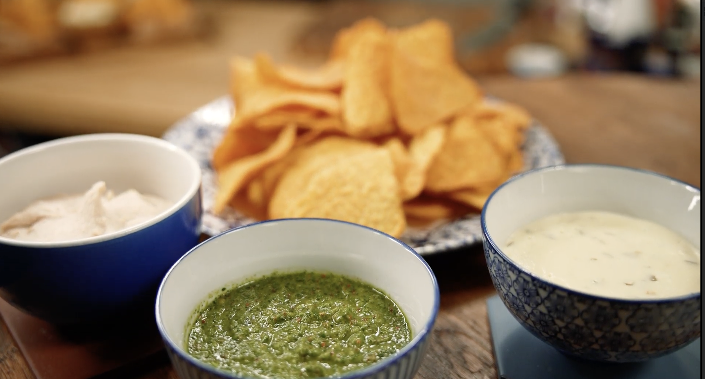 Uzkodu plate ar pupiņu humusu, koriandra salsu, jalapeño siera mērci un lielajiem tortiljas čipsiem