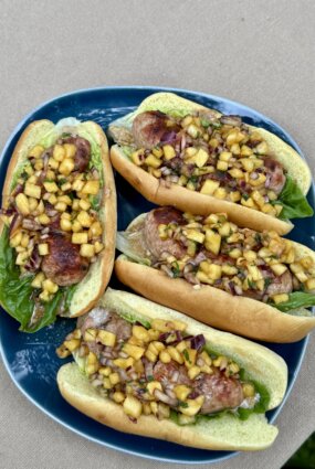 Hotdogs ar grilētu cūkgaļas kupātu, ananasu un sīpolu salsu