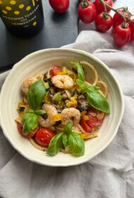 Linguine ar garnelēm, cukīnī, ķiršu tomātiem, dzelteno papriku, melnajām olīvām un baziliku ķiploku sviestā