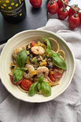 Linguine ar garnelēm, cukīnī, ķiršu tomātiem, dzelteno papriku, melnajām olīvām un baziliku ķiploku sviestā